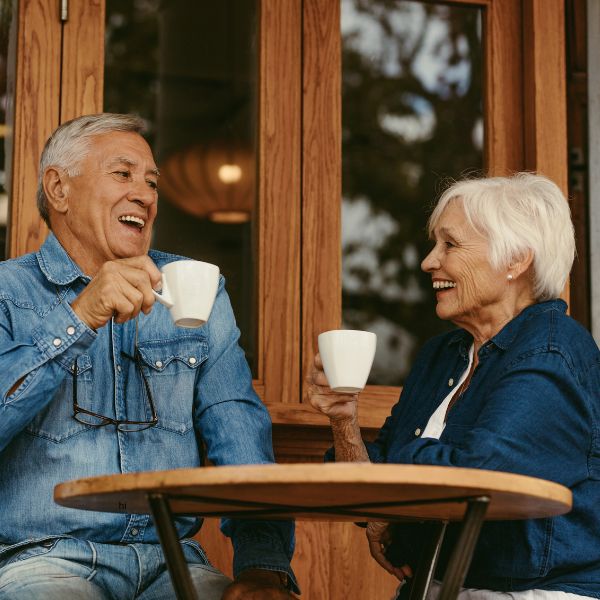 Zwei Menschen lachen bei Kaffee im Café, eine entspannte Szene für Cafés für Dates in Dresden.