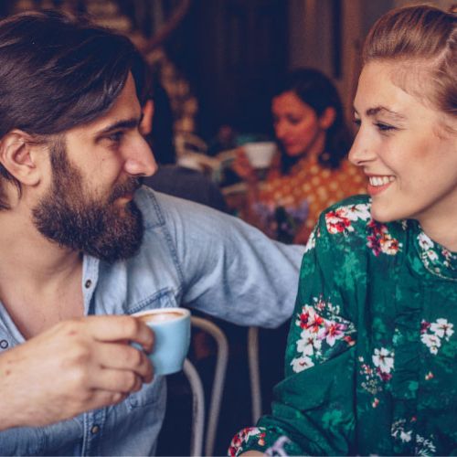 Eine Frau und ein Mann sitzen im Café bei einem romantischen Date und lernen sich besser kennen. 