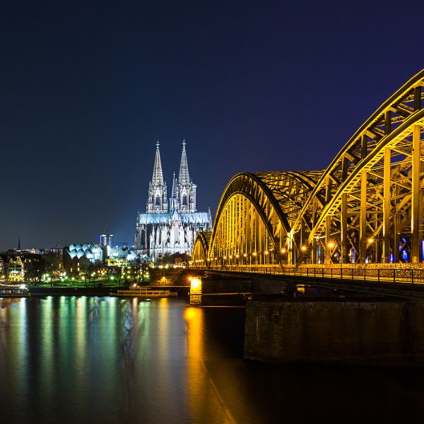 Partnersuche auf der Hohenzollernbrücke in Köln: Blick auf den Kölner Dom und die Hohenzollernbrücke bei Nacht – wo Rheinromantik, Lichter und das kölsche Lebensgefühl zusammenkommen.