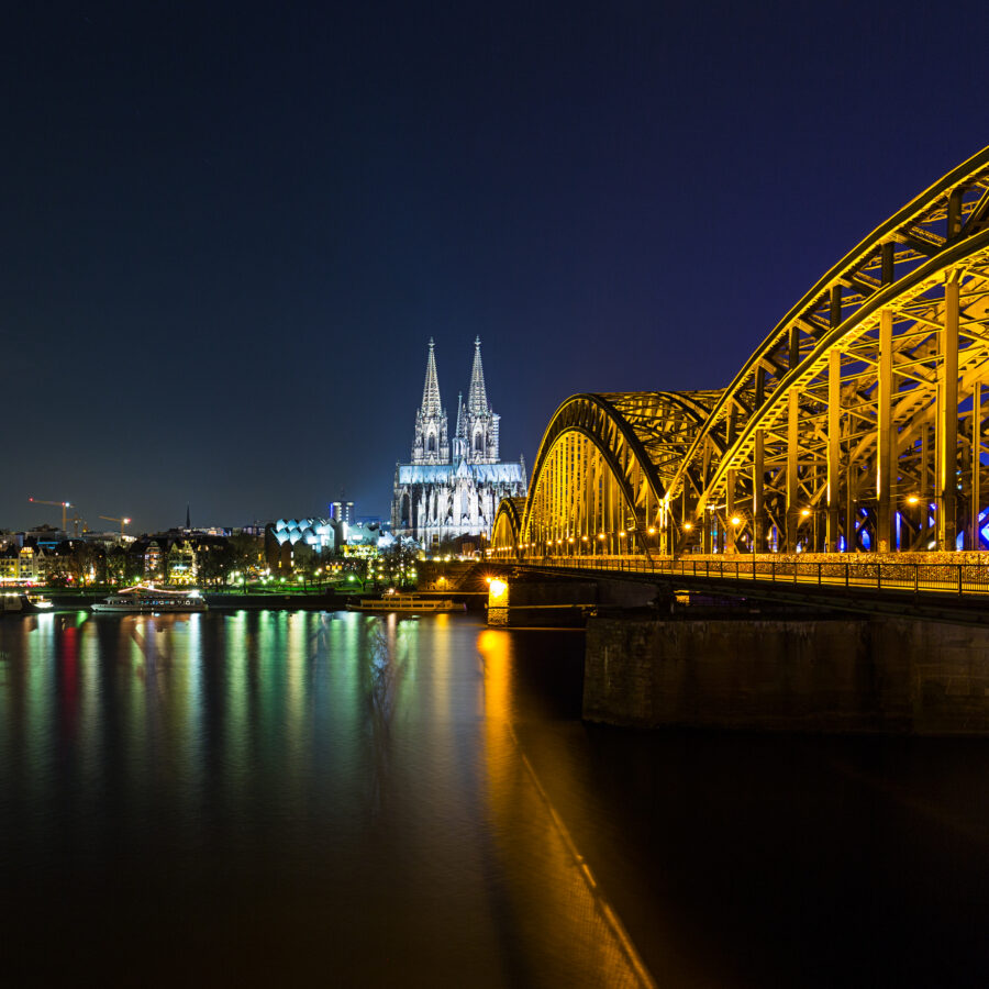 Partnersuche in Köln auf der Hohenzollernbrücke: Blick auf den Kölner Dom und die Hohenzollernbrücke bei Nacht.