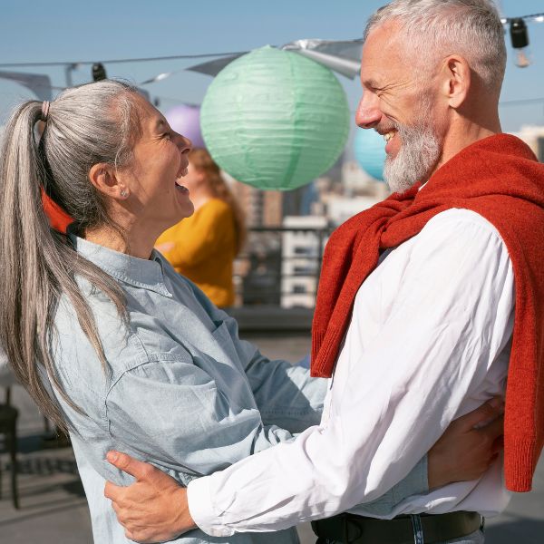 Lächelndes Paar beim Dating in Köln über 40 genießt einen gemeinsamen Moment bei einem Date auf einem Fest.