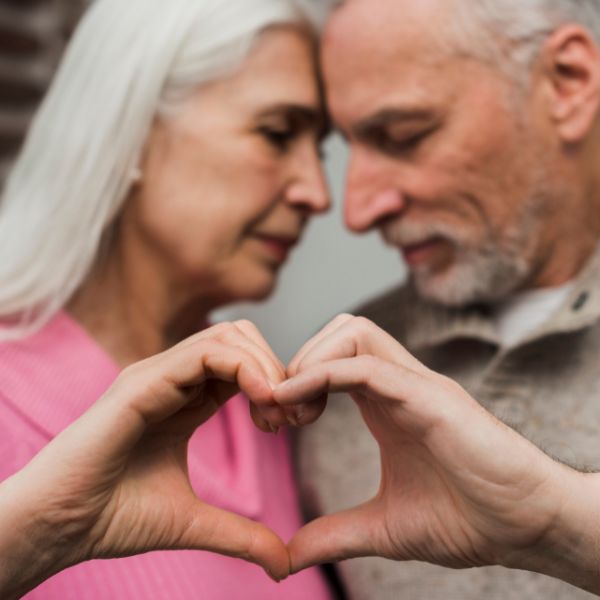 Ein verliebtes Paar über 40 hält gemeinsam ein Herz aus den Händen. Es ist ein Symbol für Vertrauen, Dating und neue Liebe über 40 in Köln.