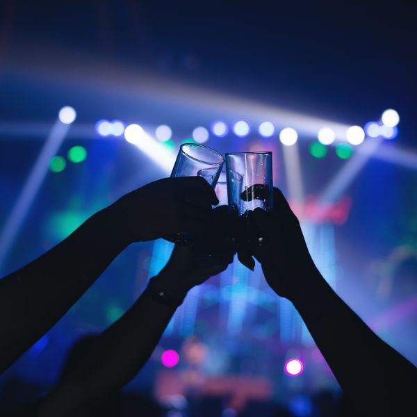 Singles stoßen in einer Hamburger Bar oder auf einer Party mit Gläsern an. Es zeigt wie Dating in Hamburg über 40 laufen kann.